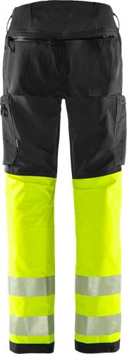 Schwarze Hose mit neonyellow-farbenen knielangen Gamaschen vor einem schwarzen Hintergrund, möglicherweise für die Sichtbarkeit bei schlechten Lichtverhältnissen konzipiert.