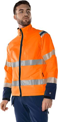 Eine Person, die eine orangefarbene Warnweste mit reflektierenden Streifen trägt, vor einem schwarzen Hintergrund stehend.