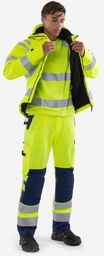 Person mit Warnschutzkleidung in signalgelb mit reflektierenden Streifen, einschließlich Jacke und Hose, von der Hals abwärts abgebildet.