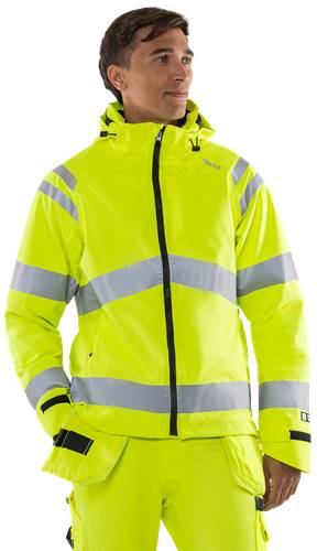Eine Person, die eine leuchtend gelbe Warnschutzjacke mit reflektierenden Streifen trägt, vor einem schwarzen Hintergrund stehend.