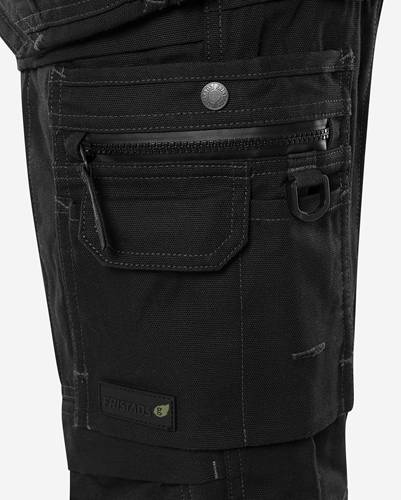 Nahaufnahme einer schwarzen Utility-Tasche mit Reißverschluss und Knopf, mit einem kleinen Logoetikett am unteren Rand.