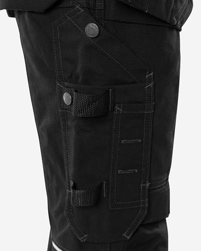 Nahaufnahme einer schwarzen Cargohose mit verstärkten Nähten und einem Knopfverschluss an der Tasche.