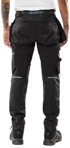 Eine Person, die schwarze taktische Cargohose mit mehreren Taschen und verstärkten Kniebereichen trägt, von der Taille abwärts vor einem schwarzen Hintergrund.