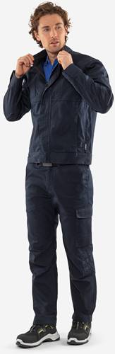 Person trägt eine marineblaue Utility-Jacke und Hose, von vorne blickend. Die Kleidung verfügt über Taschen für praktische Verwendung.