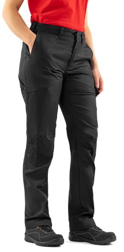 Eine Person in schwarzen Cargo-Hosen mit Händen in den Taschen, die vor einem dunklen Hintergrund steht und dabei das Design und die Passform der Hose präsentiert.