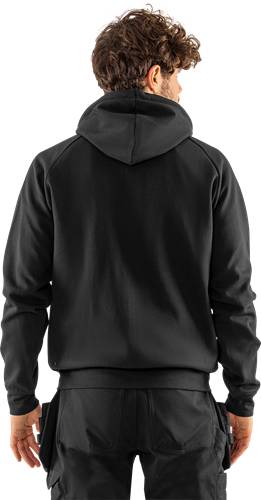 Eine Person, die eine schwarze Kapuzenjacke mit hochgezogener Kapuze trägt, von hinten betrachtet.
