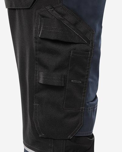 Detailaufnahme einer schwarzen Hose mit mehreren seitlichen Taschen, die detaillierte Nähte und einen dunkelblauen Stoffbereich zeigt.