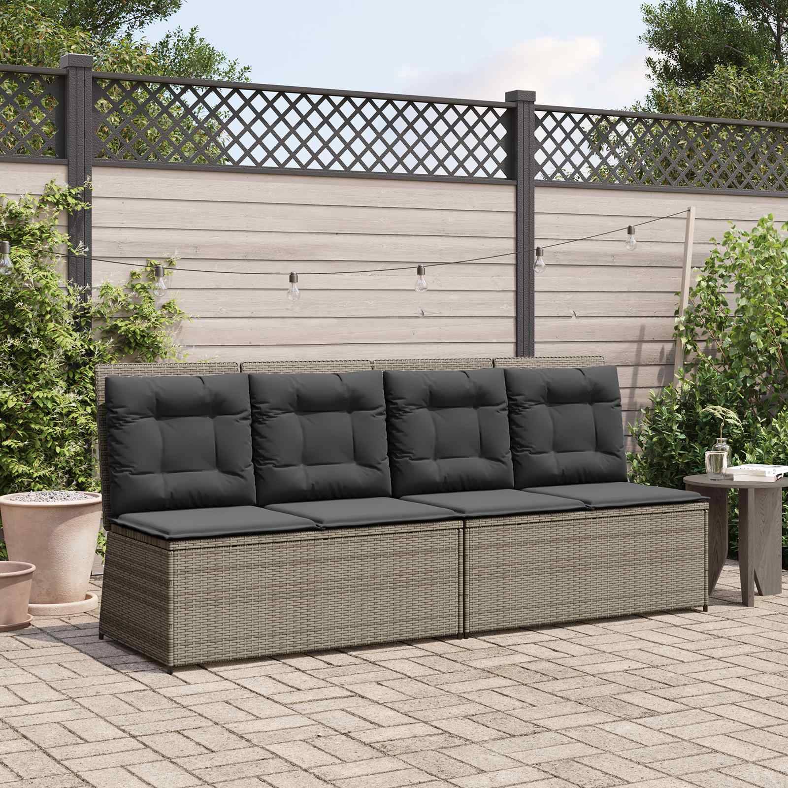 Eine Terrasse mit Rattanmöbeln, die ein gepolstertes Sofaset an einem Holzzaun zeigt. Topfpflanzen und ein kleiner Tisch vervollständigen die Szenerie.