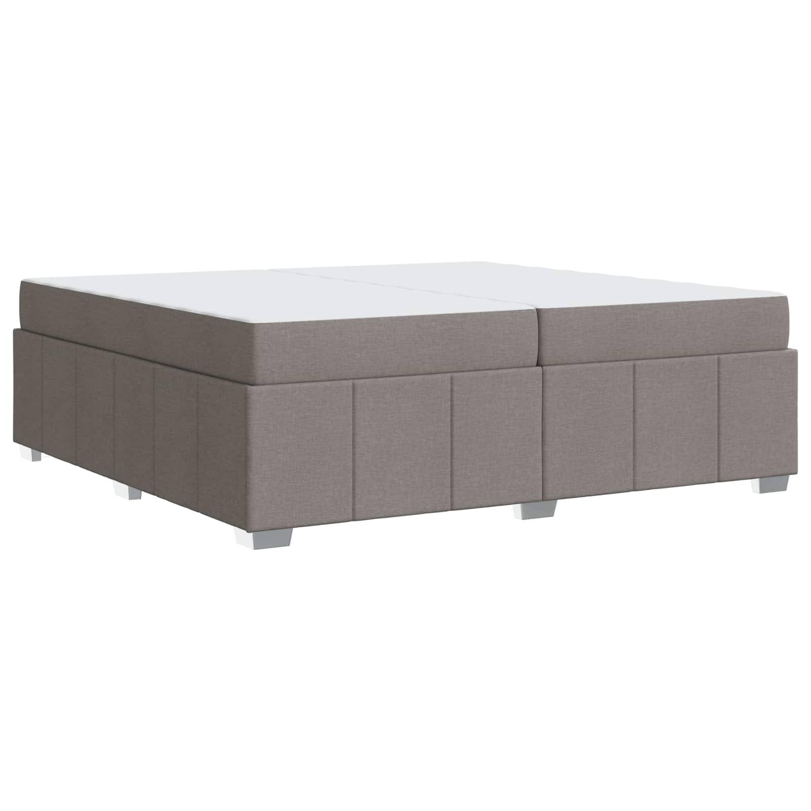 Ein hellgrau gepolsterter Hocker mit gepolsterter Oberfläche und blockförmigem Design, der als Sitzgelegenheit im Wohnzimmer oder als Couchtisch vorgesehen ist.
