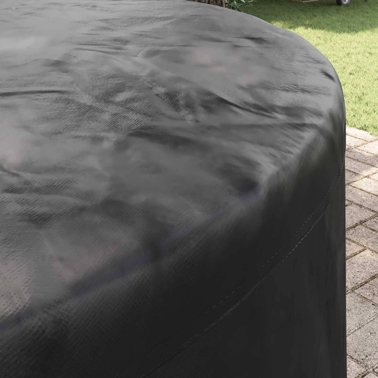 Eine runde schwarze Tischdecke mit strukturierter Oberfläche, die im Freien auf einer gepflasterten Terrasse platziert ist, wobei Gras im Hintergrund sichtbar ist.