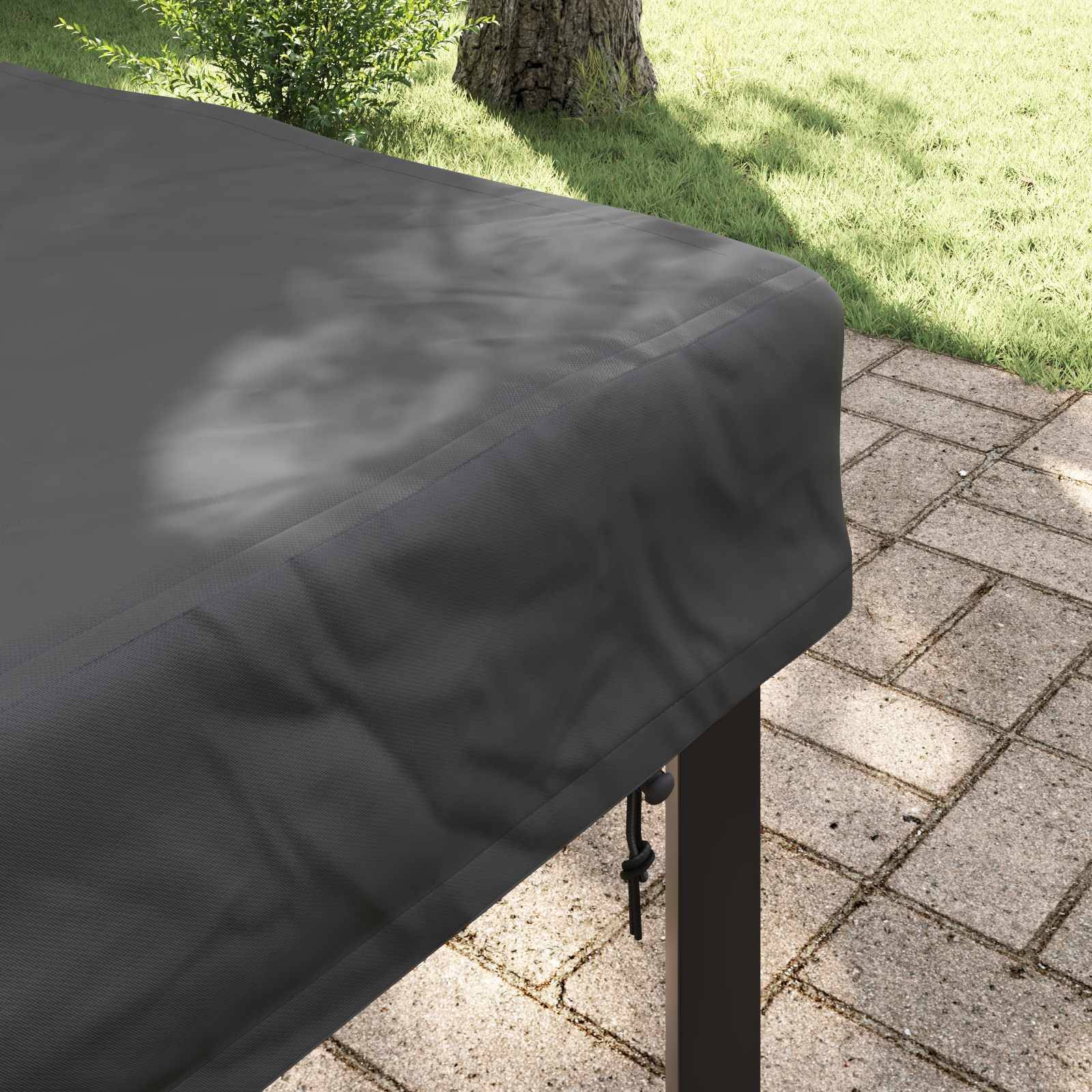 Tisch mit dunkler Abdeckung in einem sonnendurchfluteten Garten, umgeben von einem gepflasterten Steinpatio und grünem Rasen im Hintergrund.
