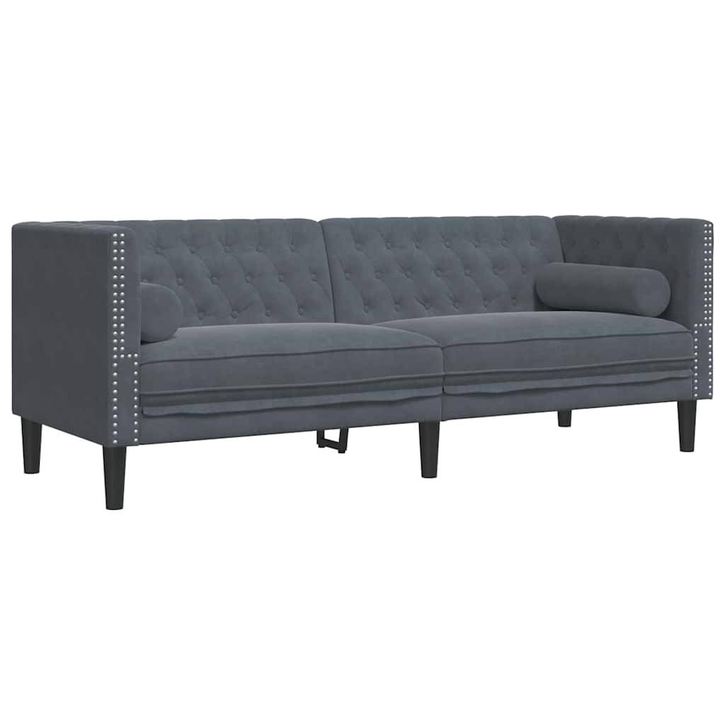 Ein dunkelgrauer, dreisitziger Sofa mit geknöpfter Polsterung, Ziernägeln an den Armlehnen und zwei zylindrischen Nackenrollen.
