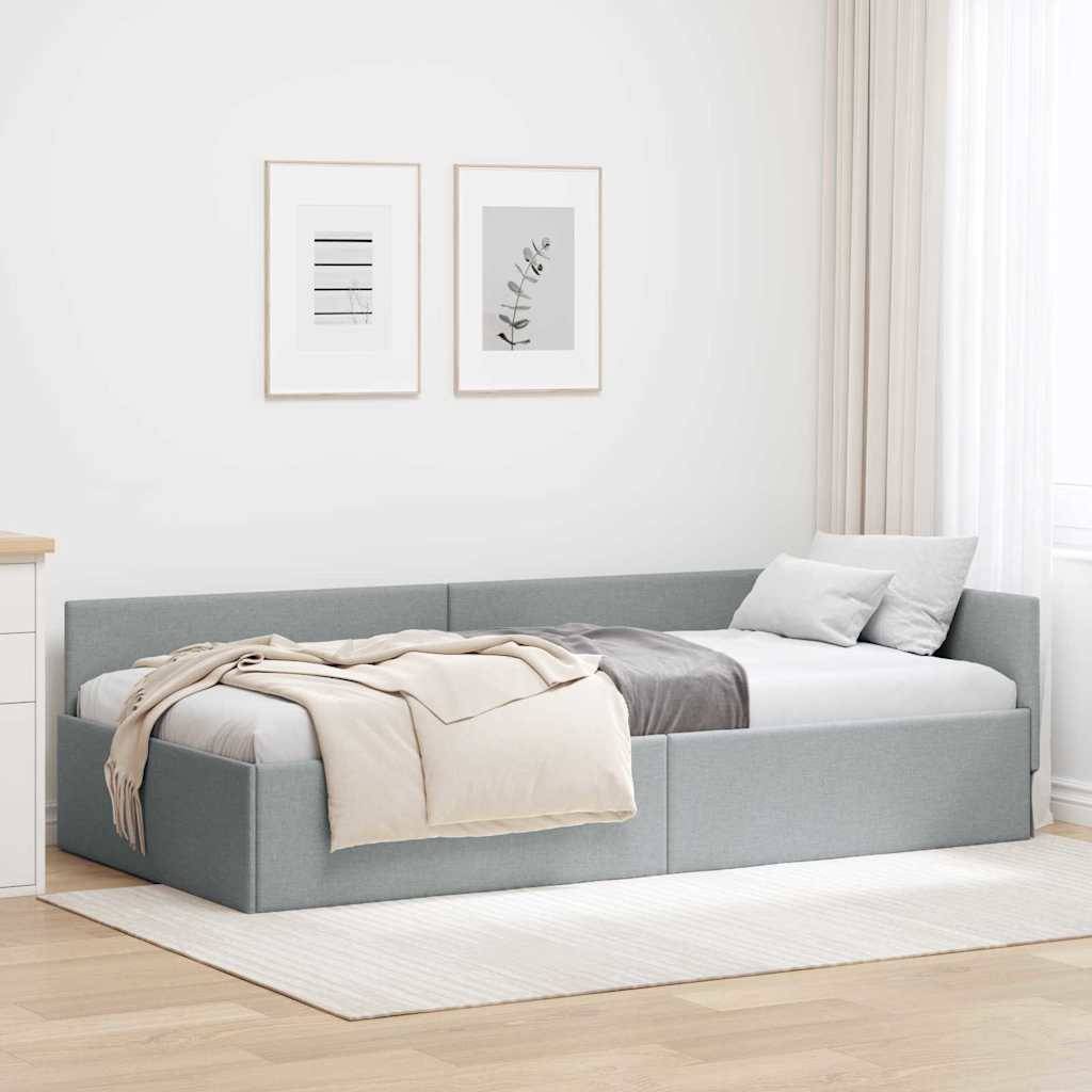 Ein modernes Schlafzimmer mit einem grauen Sektioanl-Schlafsofa, weißen und beigefarbenen Kissen, neutralen Decken, zwei gerahmten Kunstwerken an der Wand und einem helltonigen Teppich.