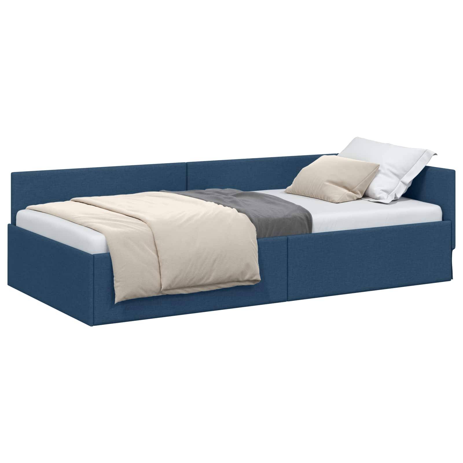 Blaugepolsterte Tagesliege mit weißer Matratze und beige-grauer Bettwäsche auf weißem Hintergrund.