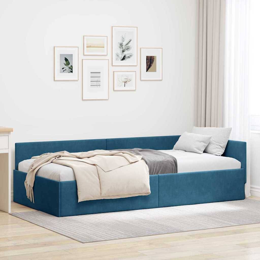 Eine gemütliche Schlafzimmerecke mit einem blauen Tagesbett, cremefarbenen Decken und weißen Kissen. Sechs Kunstwerke hängen an der Wand über dem Bett.