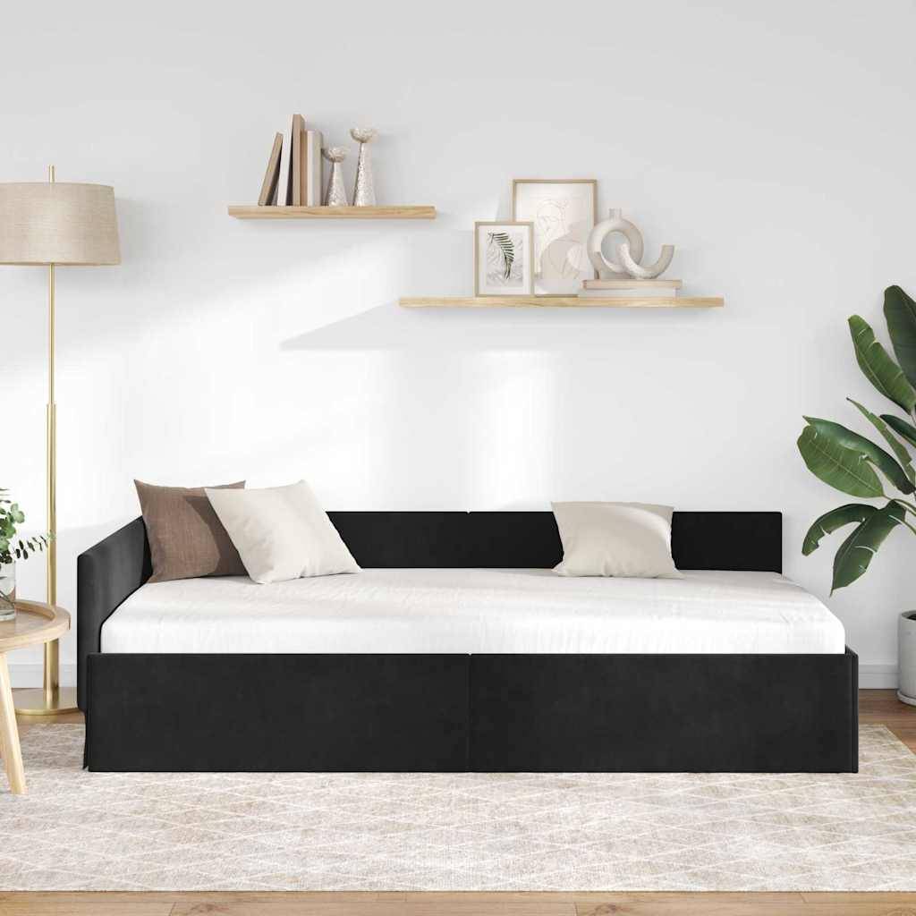 Ein modernes Wohnzimmer ist mit einem schwarzen Tagesbett mit weißen und braunen Kissen, einer Stehleuchte, hängenden Regalen und einer Topfpflanze auf der rechten Seite ausgestattet.