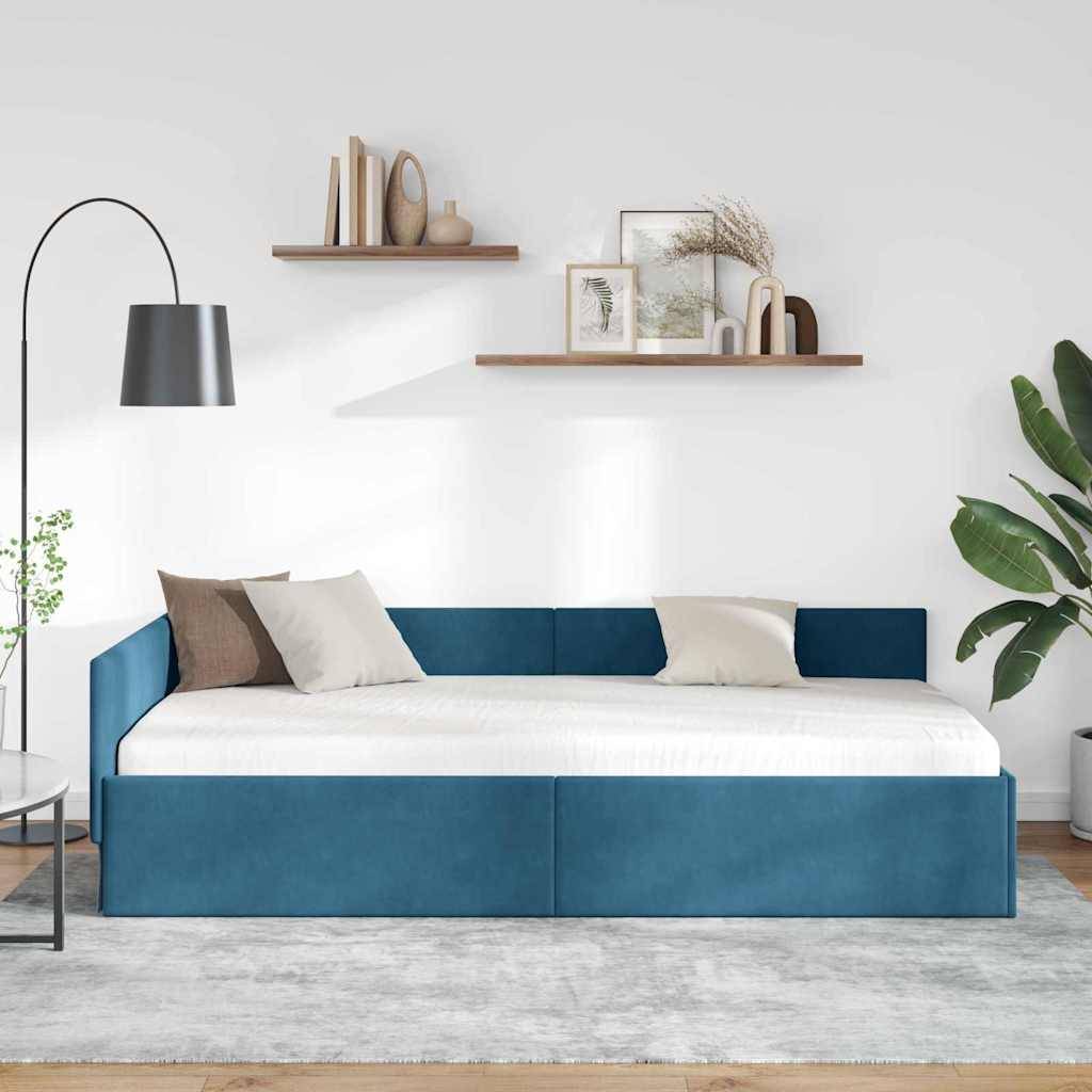 Ein modernes Wohnzimmer mit einem blauen Schlafsofa mit weißen Kissen, einer Stehleuchte, schwebenden Holzregalen mit Dekoration, einer Pflanze und einem neutralen Teppich.