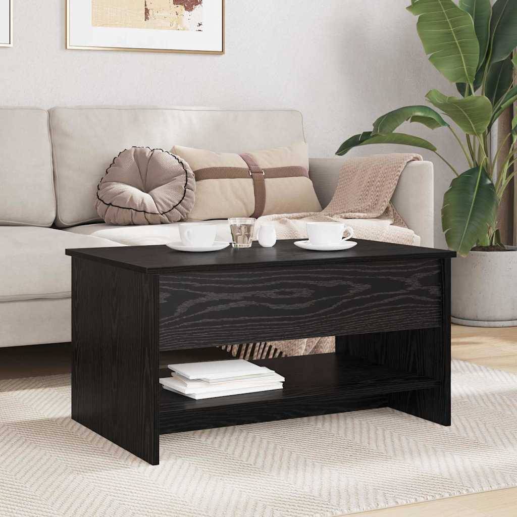 Ein schwarzer Holz-Couchtisch in einem Wohnzimmer, mit Tassen und einem Teller darauf. Beiges Sofa mit dekorativen Kissen und einer Pflanze in der Nähe.