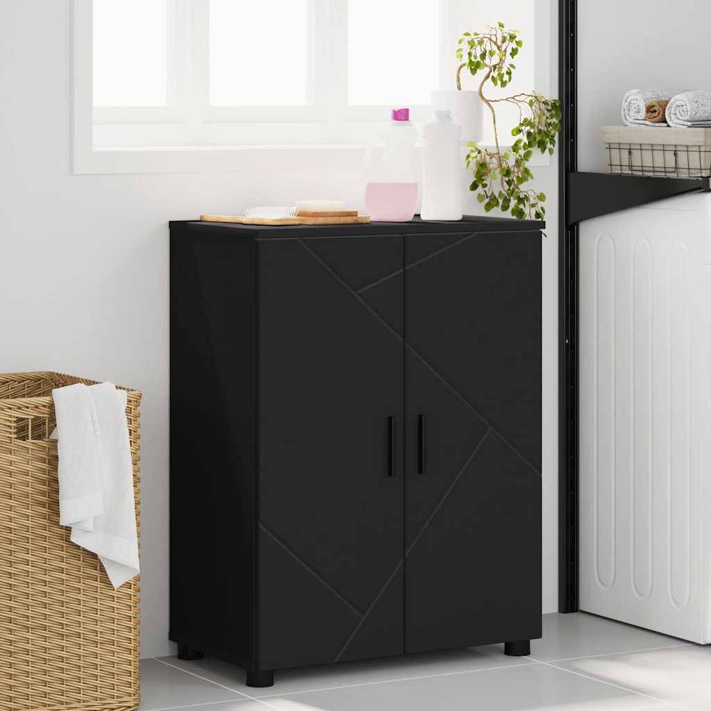 Ein schwarzer Schrank mit zwei Türen steht in einem Waschraum, auf dem gefaltete Handtücher und Flaschen liegen. Eine Waschmaschine und ein Weidenkorb befinden sich in der Nähe.