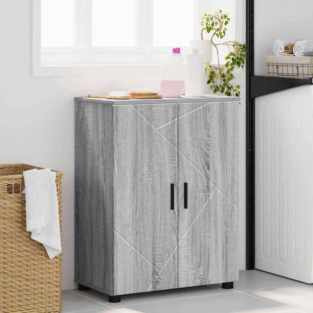 Ein Holzschrank mit einem geometrischen Muster steht in einem Waschraum neben einer Waschmaschine. Eine Pflanze, Waschmittel und zusammengelegte Handtücher befinden sich oben darauf.