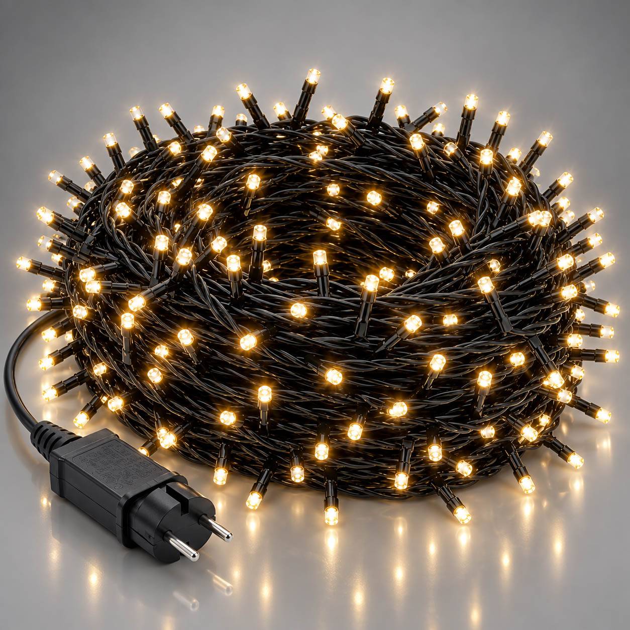 Aufgerollte schwarze Schnur mit warmweißen LED-Leuchten mit Stecker, gezeigt auf hellgrauem Hintergrund.