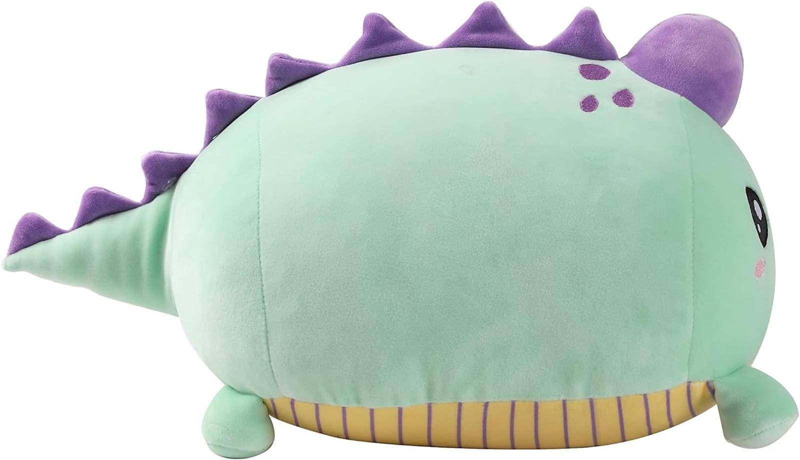 Grünes Plüsch-Dinosaurier-Spielzeug mit violetten Rückenstacheln, kurzen Beinen und gestreiftem Bauch, in Seitenansicht auf weißem Hintergrund dargestellt.