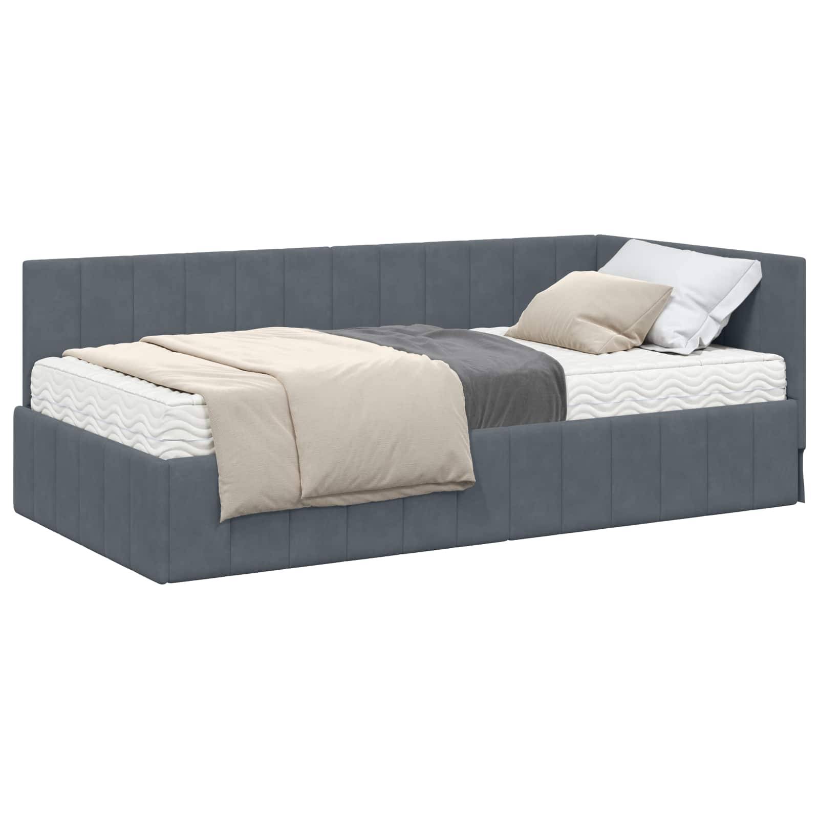 Ein modernes graues Tagesbett mit einer wellenförmig gemusterten Matratze, bekrönt von einem weißen Kissen und einer beige Decke, die sich elegant drapiert.