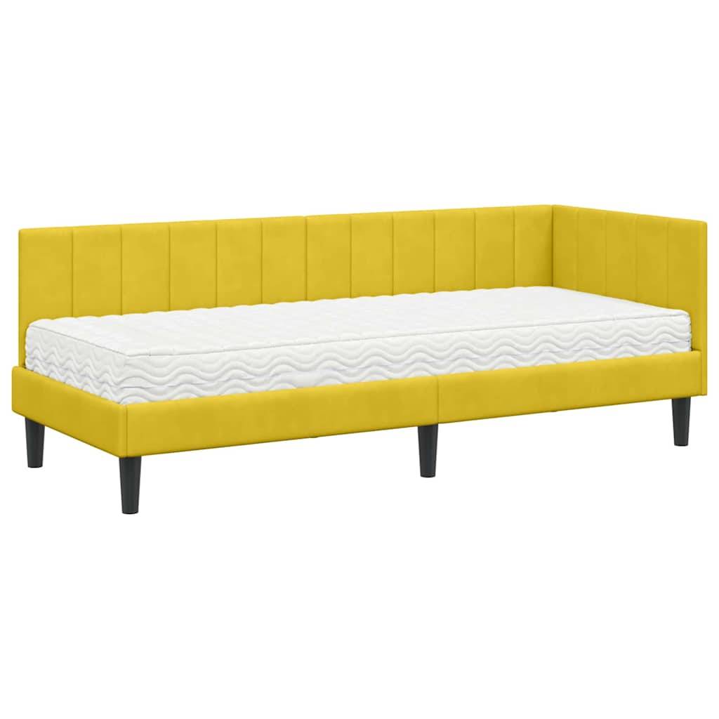 Gelbes gepolstertes Tagesbett mit einer weißen Matratze, versehen mit schwarzen Beinen und einem modernen, schlichten Design.