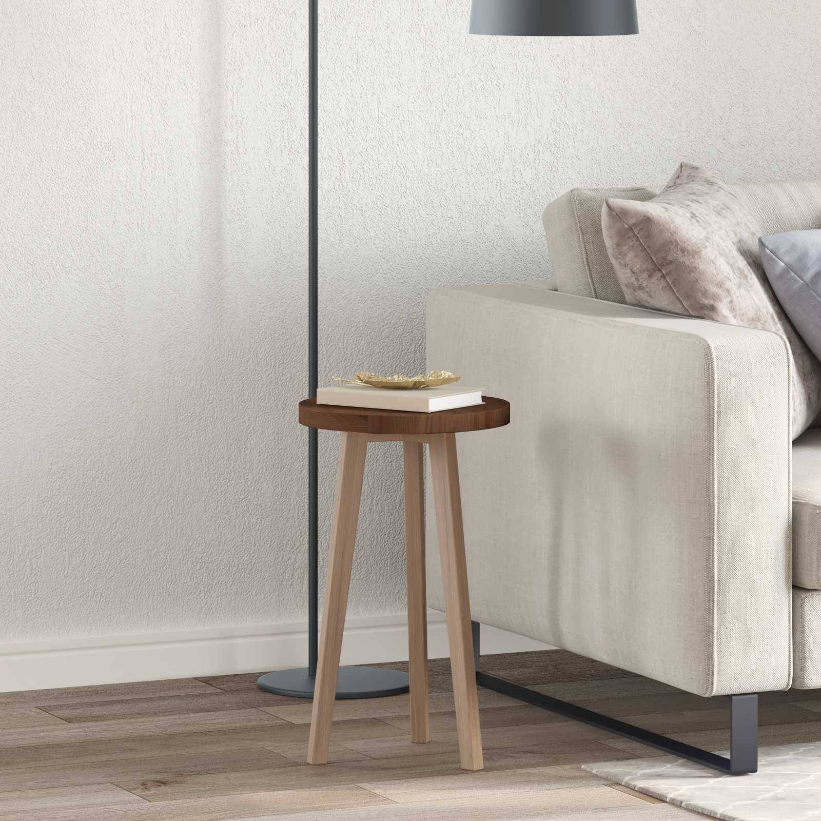 Eine moderne Wohnzimmerecke mit einem hellbeigen Sofa, einem Beistelltisch aus Holz, auf dem ein geschlossenes Buch liegt, und einer Stehlampe daneben.