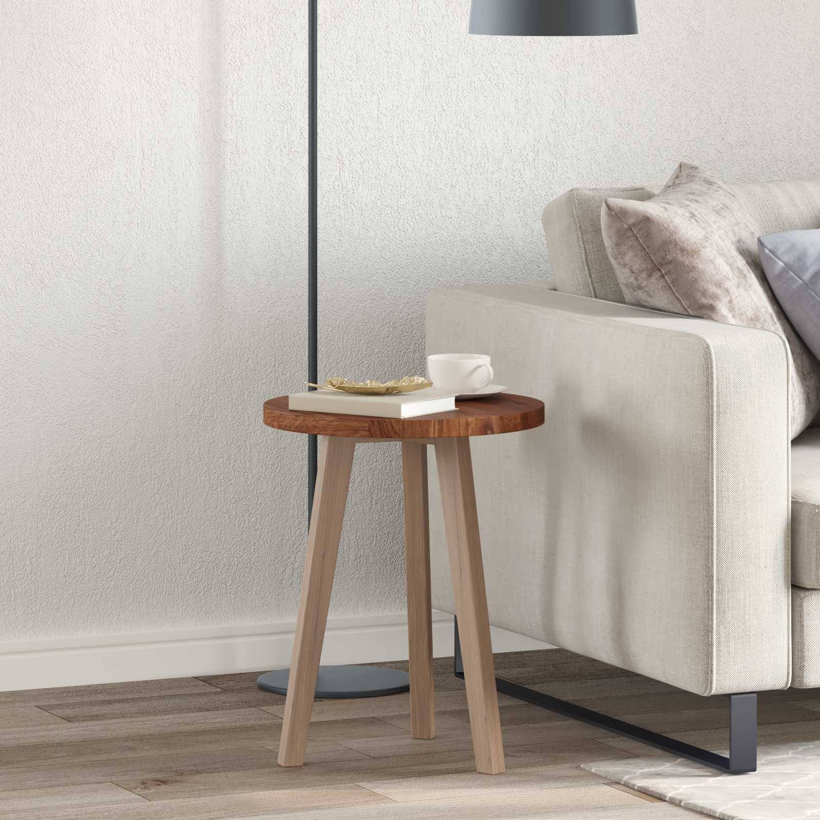 Eine moderne Wohnzimmerecke mit einem hellgrauen Sofa, beigen Kissen, einem Holzseitentisch und einer schwarzen Stehlampe auf einem Holzboden.