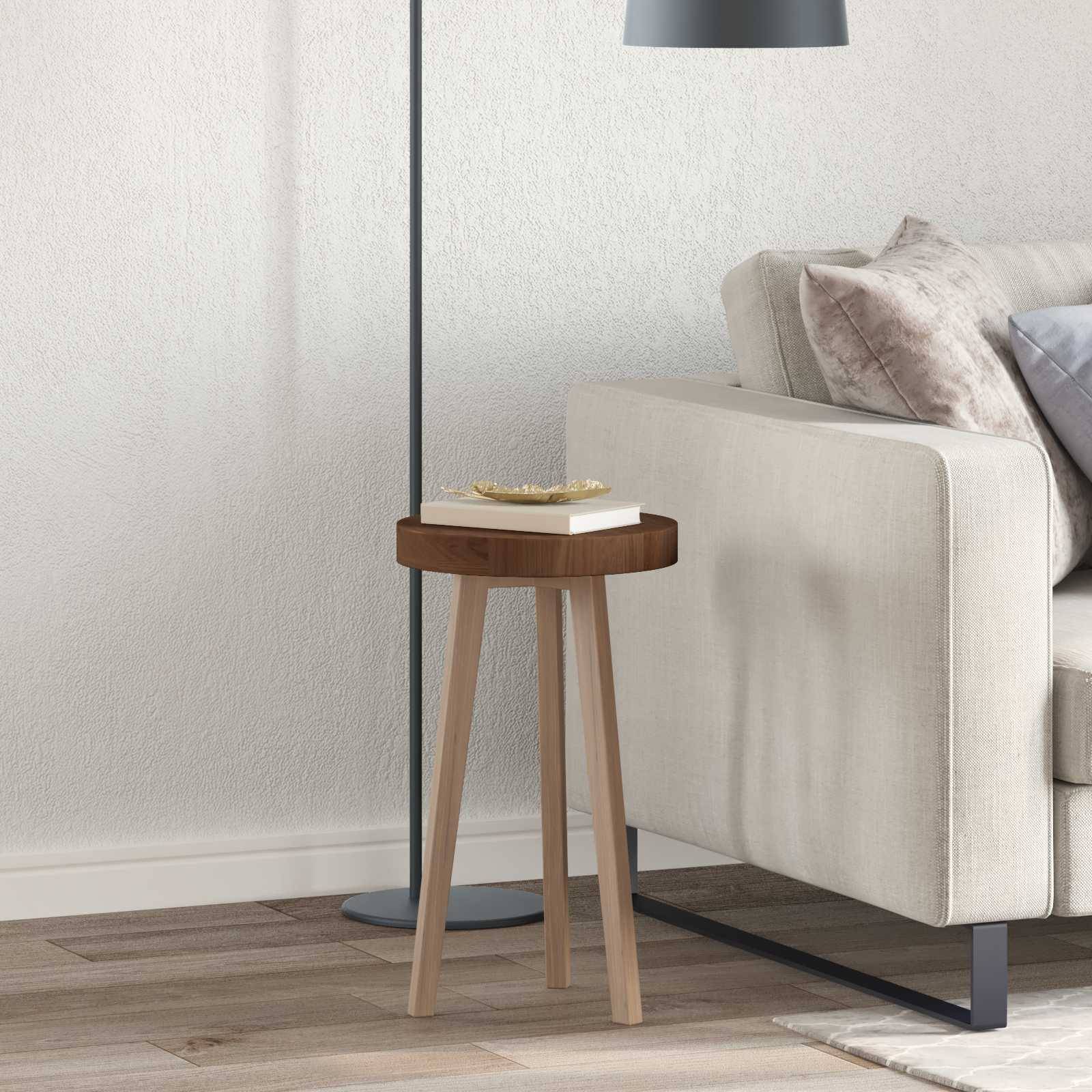 Eine gemütliche Ecke im Wohnzimmer mit einem beigen Sofa, weichen Kissen, einem Holzseitentisch mit einem Buch und einer modernen Stehlampe für gedämpftes Licht.