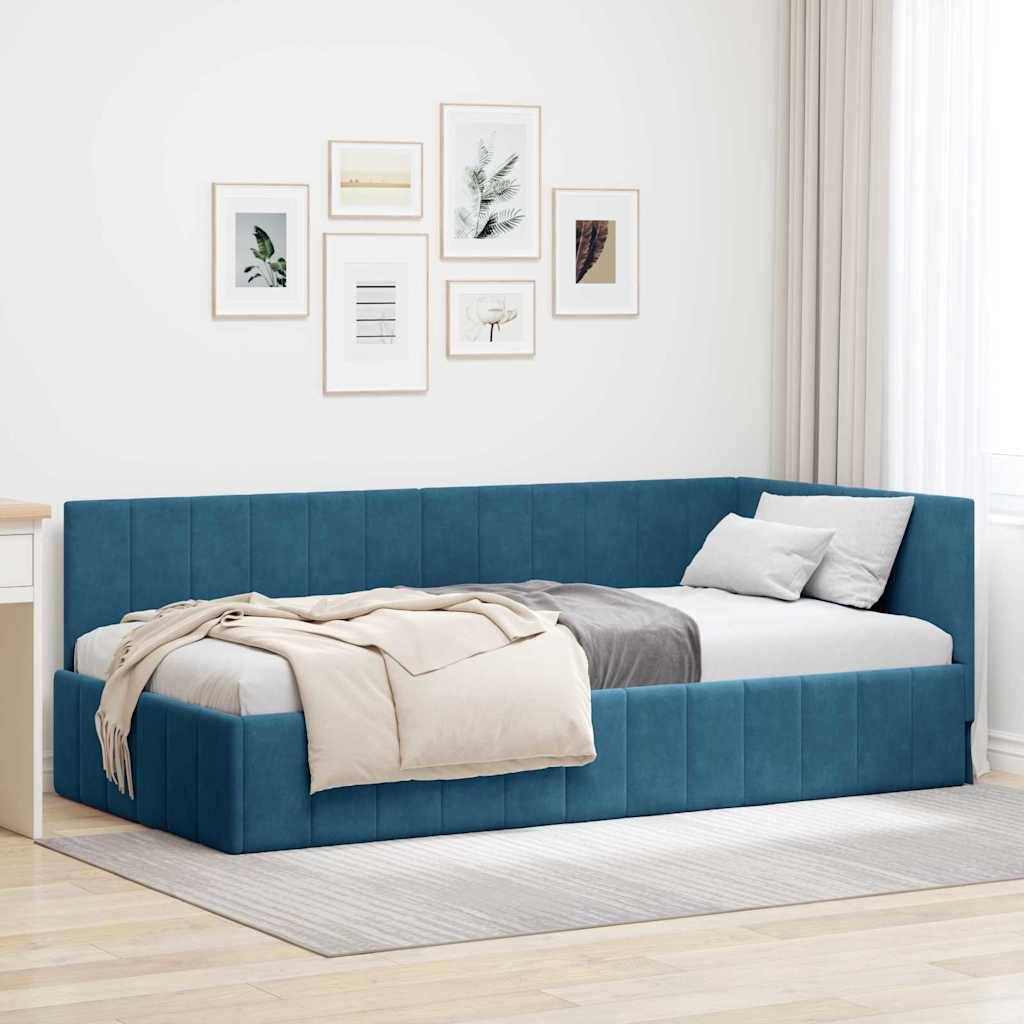 Ein modernes Schlafzimmer mit einem blauen Tagesbett, einer beigen Decke und grauen Kissen. Die weißen Wände sind mit einer Galerie naturthematischer Kunstwerke geschmückt. Natürliches Licht von einem Fenster durchflutet den Raum.
