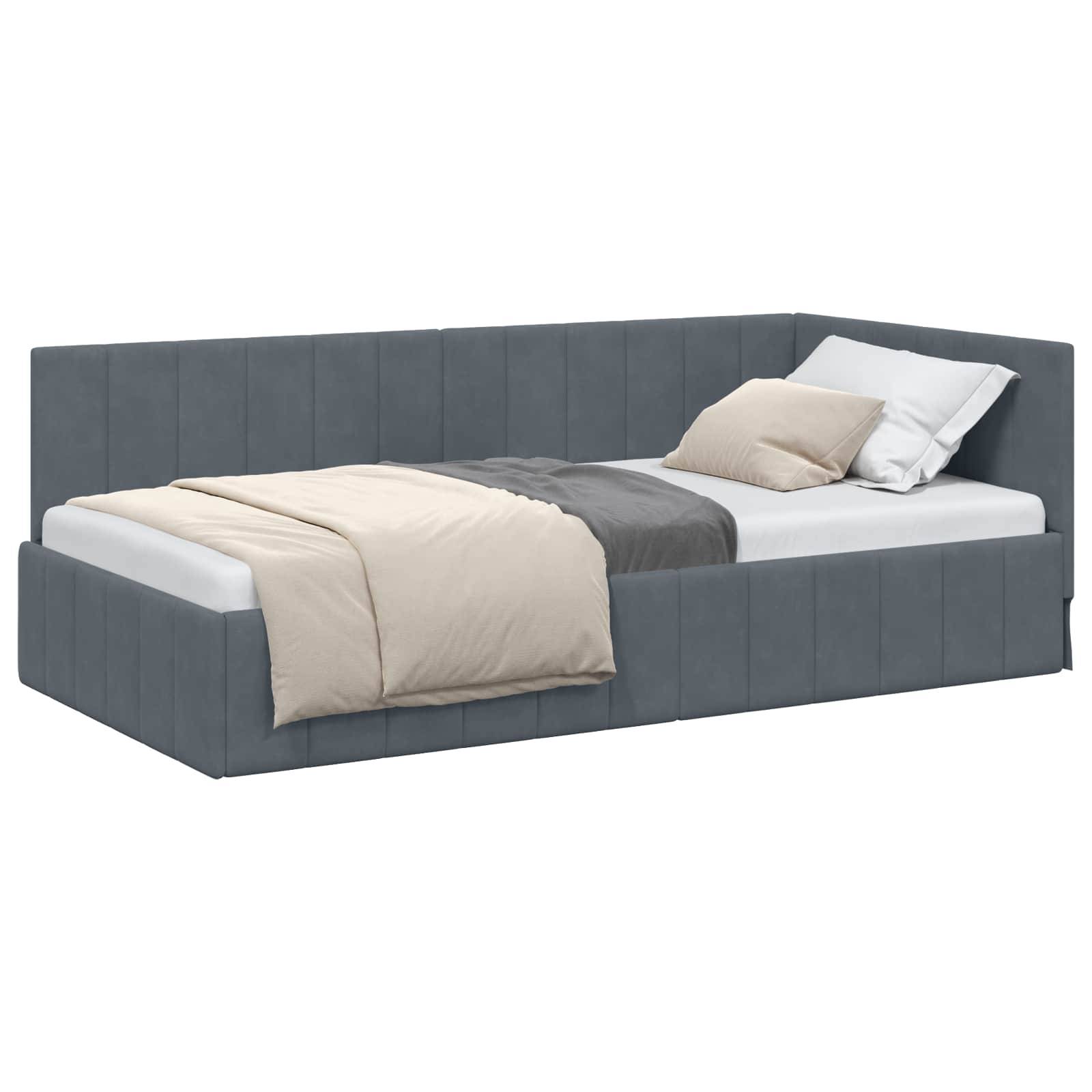 Ein grau gepolstertes Tagesbett mit einer weißen Matratze, beige und grau gemusterter Bettwäsche und einem Kissen ist vor einem weißen Hintergrund positioniert.