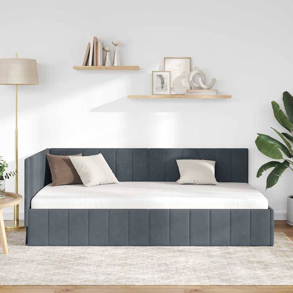 Ein modernes Schlafzimmer mit einem dunkelgrau gepolsterten Bett. Zwei beige Kissen, Holzregale mit Dekorationselementen darüber und eine Lampe auf der linken Seite.