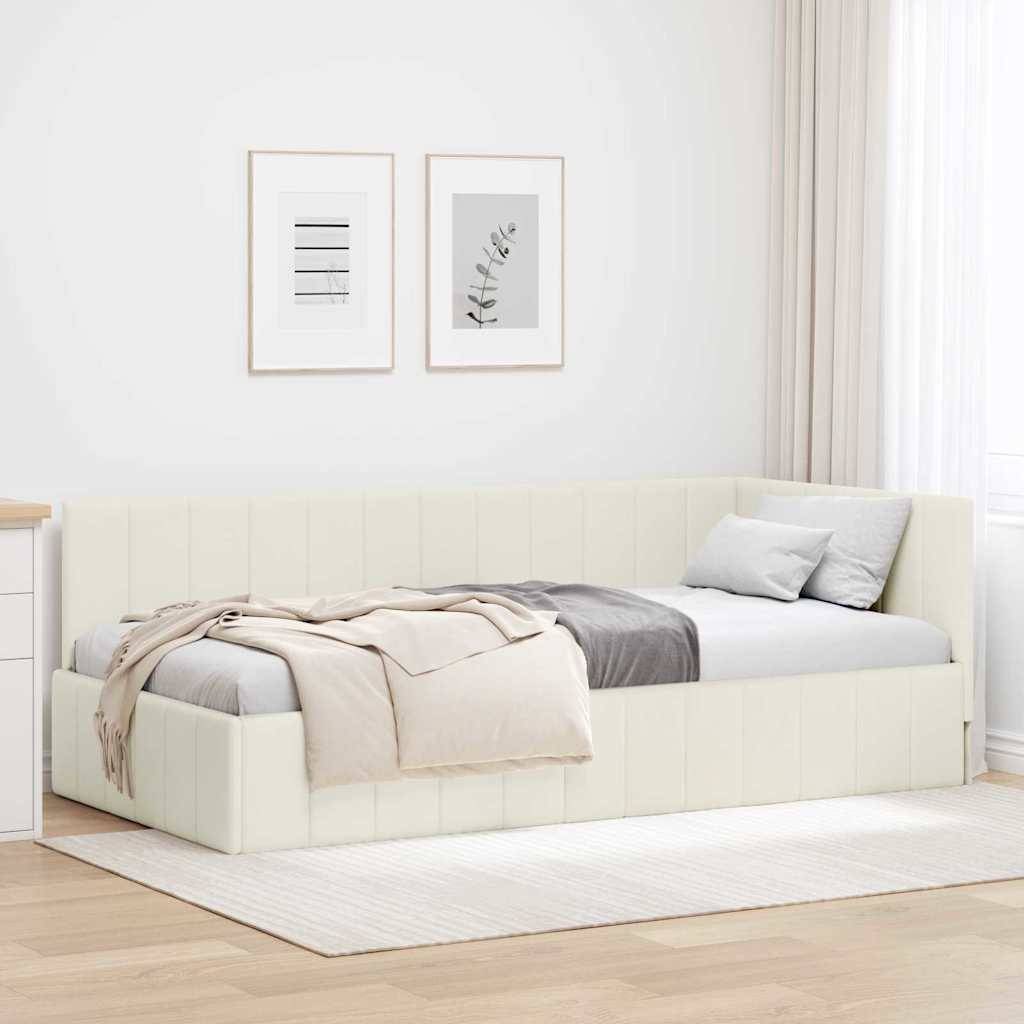 Ein modernes Schlafzimmer verfügt über ein cremefarbenes Tagesbett mit Kissen und einer Decke, weiße Wände, gerahmte Kunstwerke und Licht, das durch ein Fenster strömt.
