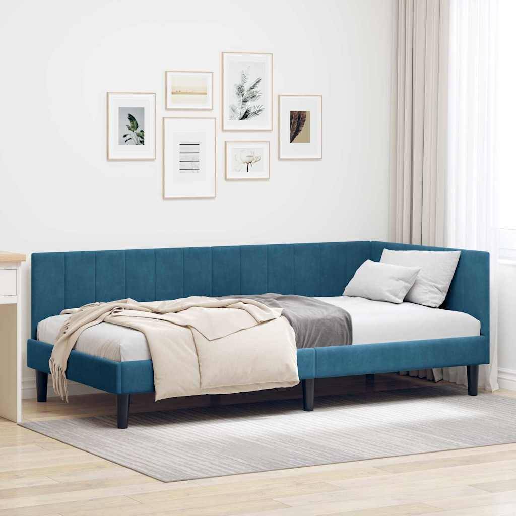 Ein minimalistisches Schlafzimmer mit einem petrolblauen gepolsterten Bett, beige-weißer Bettwäsche und dekorativen gerahmten Kunstwerken an einer weißen Wand. Helle Gardinen verhüllen ein Fenster.