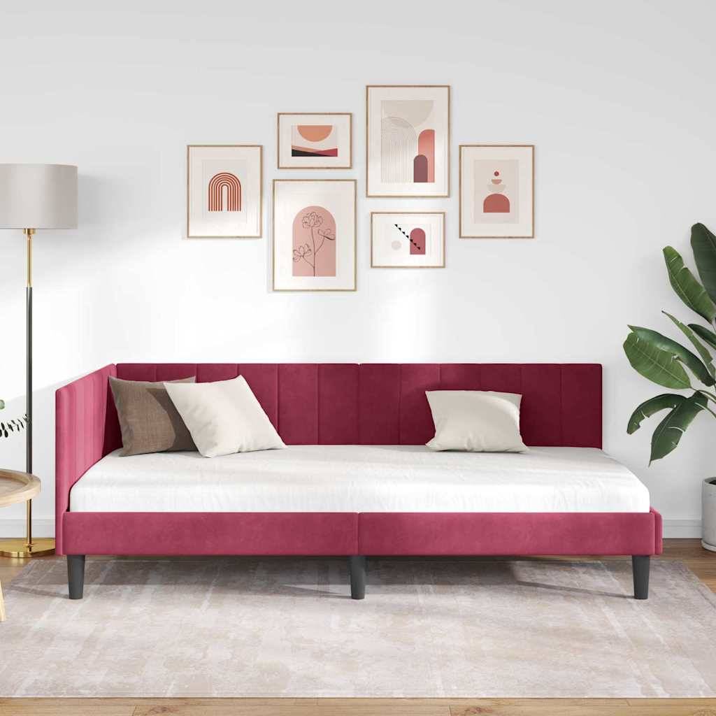 Ein modernes Zimmer mit einem rosa gerahmten Bett mit weißen und braunen Kissen, einer Galeriewand mit abstrakter Kunst, einer Stehlampe und einer Topfpflanze.