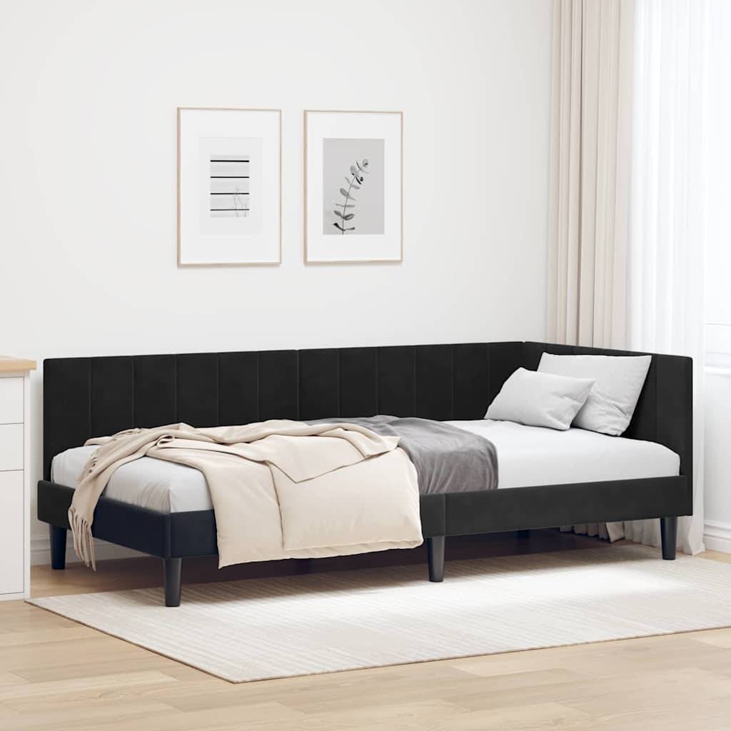 Ein modernes Schlafzimmer mit einem schwarzen Eckbett, einer beigefarbenen Decke und weißen Kissen. Zwei minimalistische Kunstrahmen hängen an den hellfarbigen Wänden.