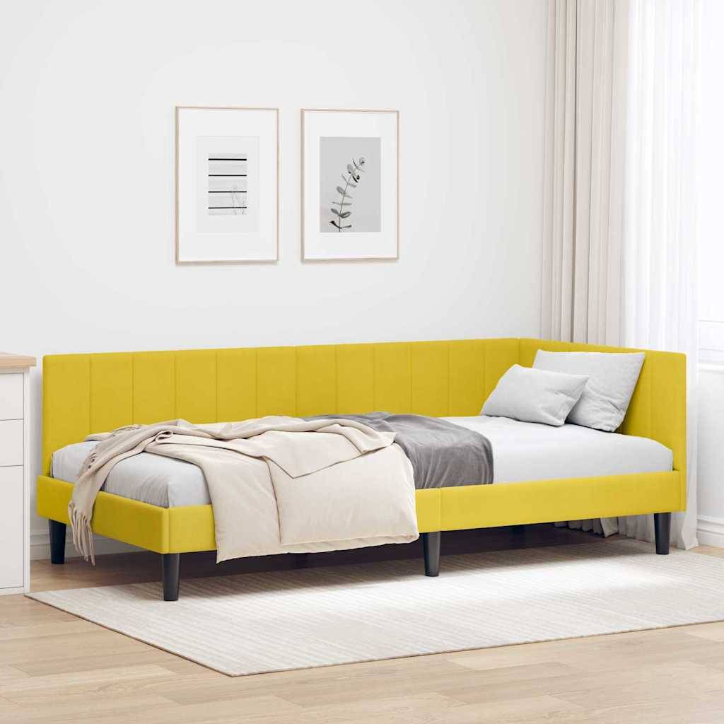 Gelbes Polsterbett mit weißer Bettwäsche und Kissen in einem hellen, minimalistischen Schlafzimmer mit gerahmten Wandbildern und hellem Teppich.