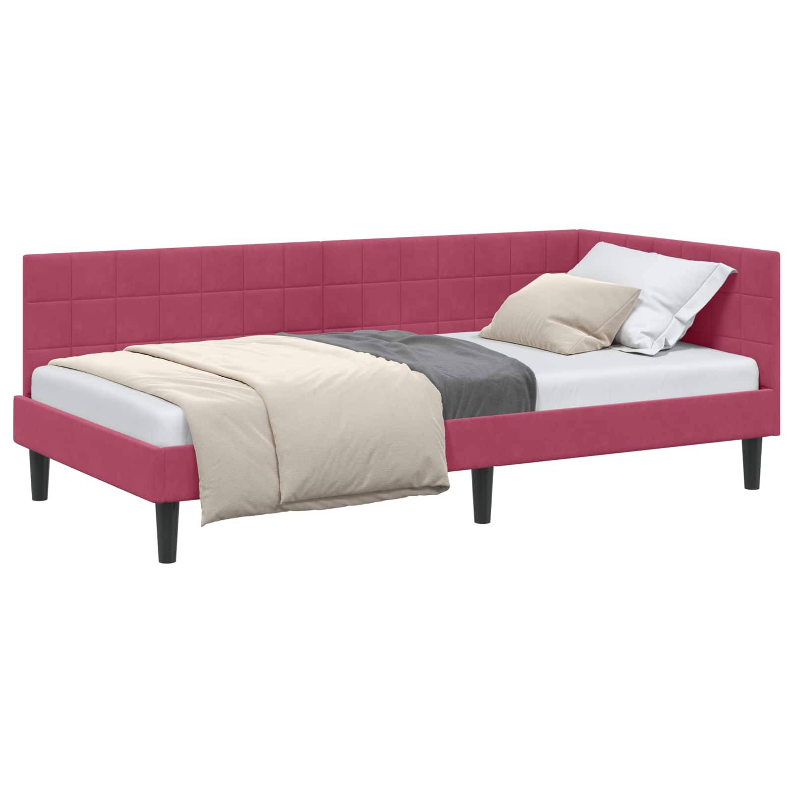 Ein rosa gepolstertes Eckbett mit einem weißen Kissen, einer beigen Decke und einem grauen Steppdecke. Das Bett zeichnet sich durch ein modernes Design mit dunklen Beinen aus.