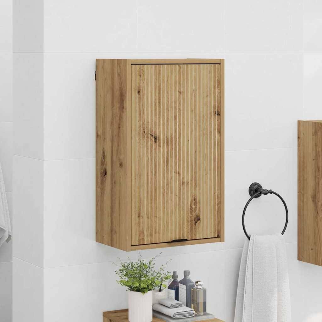 Holzschrank für das Badezimmer mit vertikaler Maserung, der an einer weißen gefliesten Wand montiert ist. Darunter eine Arbeitsplatte mit Seife, einem Handtuch und einer Topfpflanze.