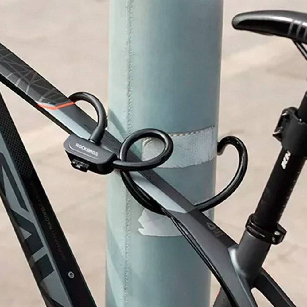 Ein schwarzes Fahrrad ist mit einem Zahlenkombinationsschloss sicher an einem Metallpfosten angeschlossen. Das Bild unterstreicht die Sicherheit von Fahrrädern.