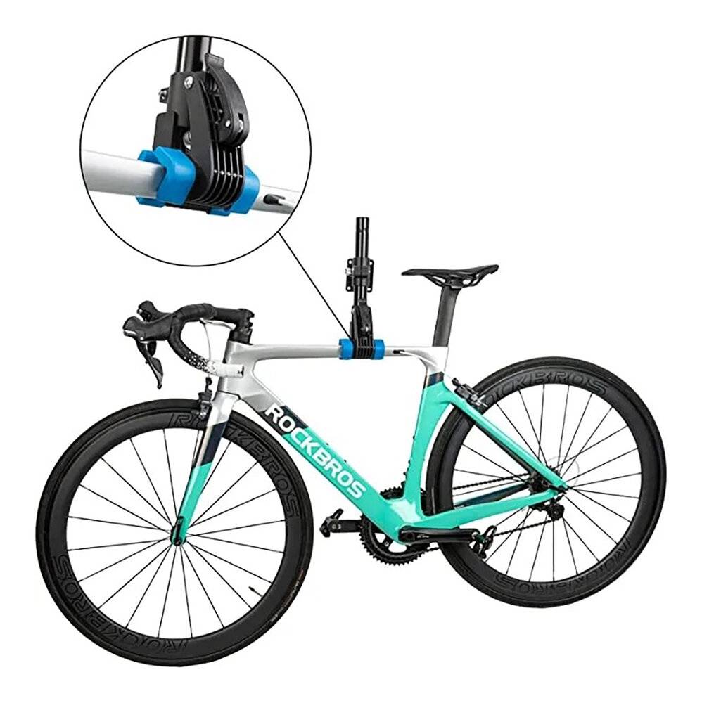 Weiß-türkises Fahrrad auf einem vertikalen Reparaturständer montiert mit einer Nahaufnahme, die die Klemme zeigt, die den Fahrradrahmen sicher hält.