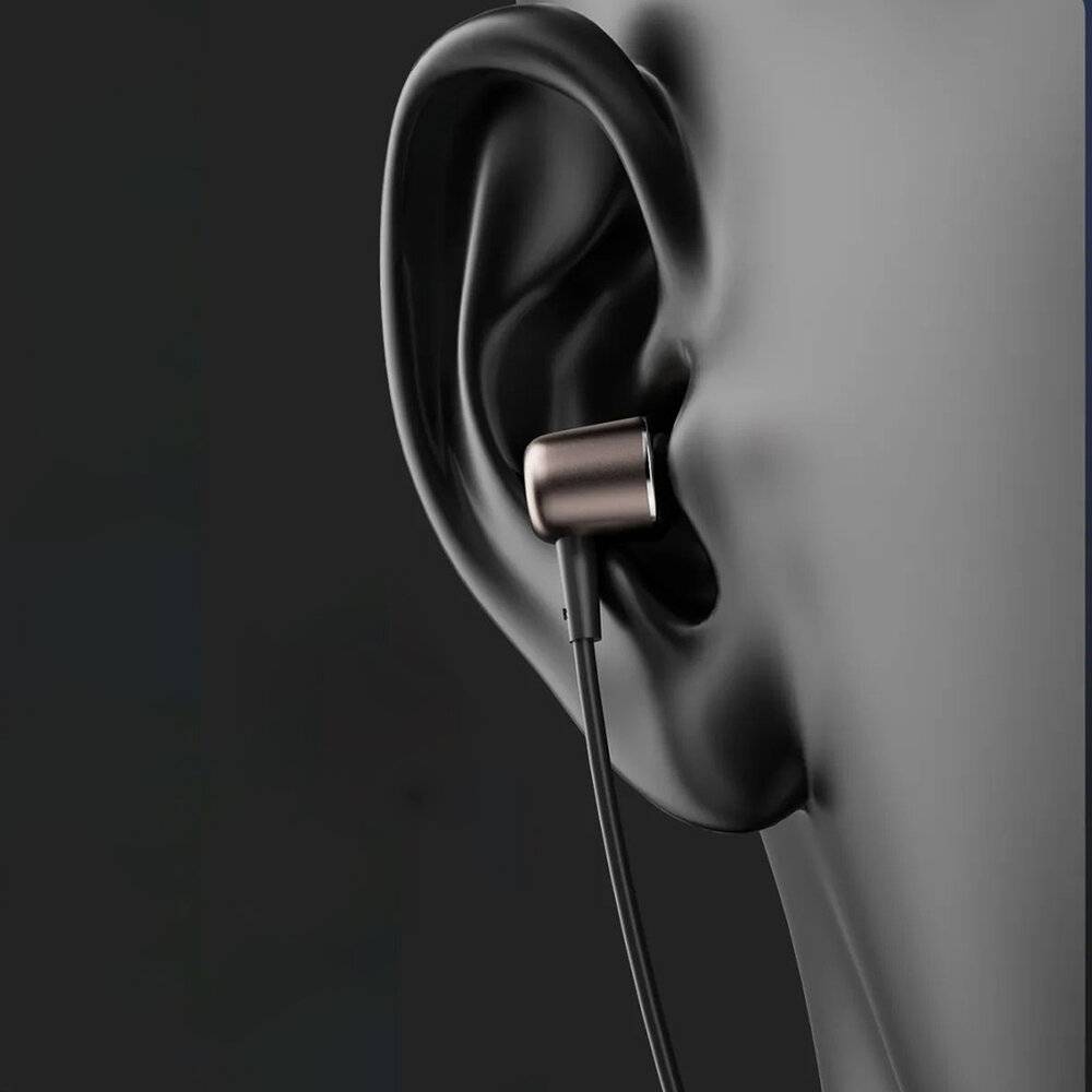 Ohr mit eingefügtem schwarzem Ohrhörer, Nahaufnahme, die die Passform und das Design des Ohrhörers im Ohr hervorhebt.