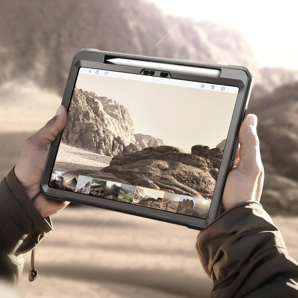 Eine Person hält ein Tablet in der Hand, auf dem ein Foto von felsigen Landschaften angezeigt wird. Die Bildergalerie auf dem Bildschirm deutet auf Reise- oder Fotografie-Themen hin.