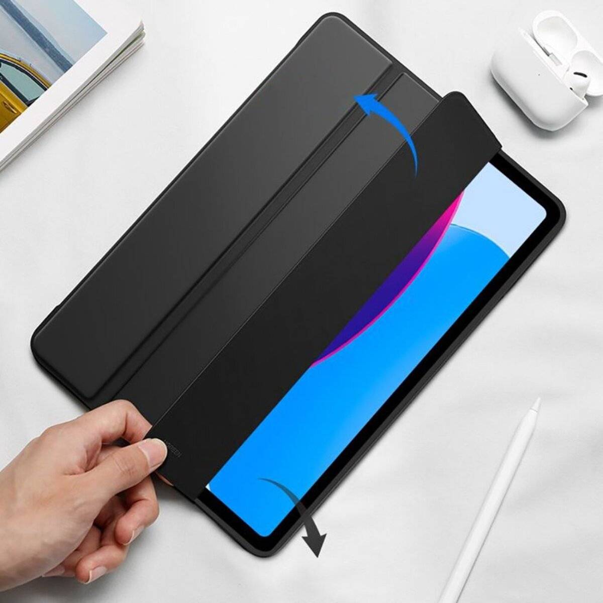 Eine Person öffnet eine Tablet-Hülle und enthüllt einen beleuchteten Bildschirm mit farbenfrohem Display. Ein Stylus liegt neben dem Tablet auf einer weißen Oberfläche.