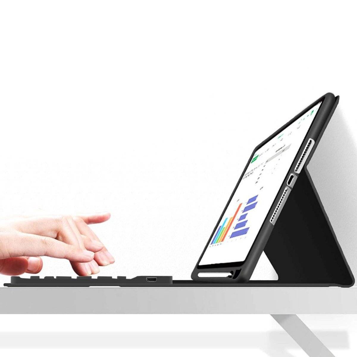 Eine Person tippt auf einer kabellosen Tastatur, während ein Tablet auf einem Ständer Diagramme anzeigt. Das Tablet zeigt Grafiken, die auf Datenanalyse hindeuten.