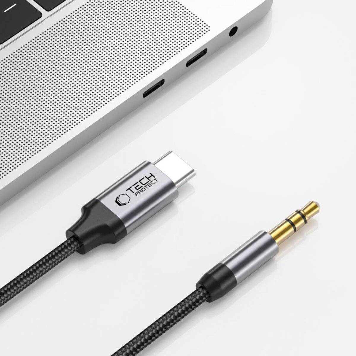 Eine Nahaufnahme eines Laptops mit drei USB-C-Anschlüssen und einem Audiokabelanschluss mit geflochtener Designstruktur daneben.