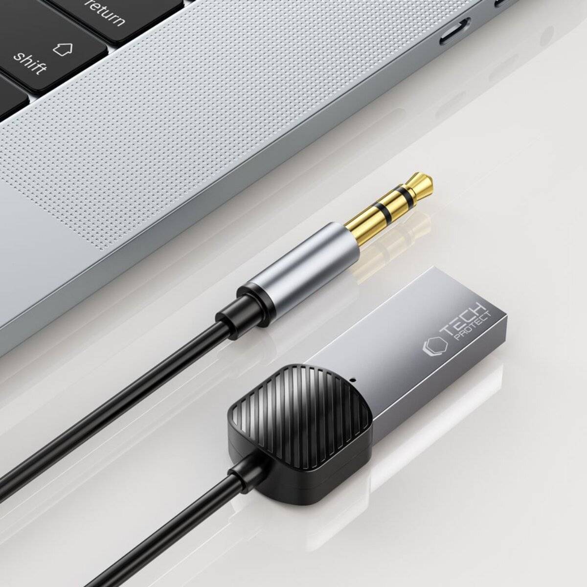 Eine Laptop-Tastatur wird mit einer Nahaufnahme eines Audio-Adapters der Marke 