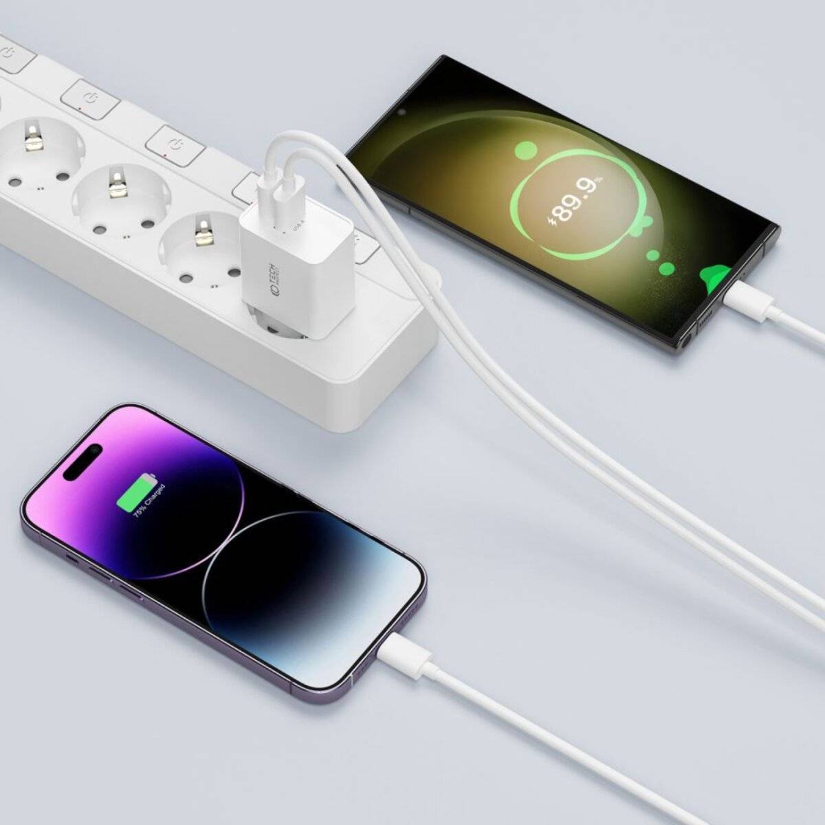Ein Steckerleiste mit mehreren Anschlüssen lädt ein Smartphone und andere elektronische Geräte über USB-Kabel, was auf eine effiziente Stromverteilung hinweist.